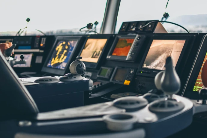 Bridge navigation console with digital radar displays and ship control systems for real-time monitoring and maritime vessel operations.